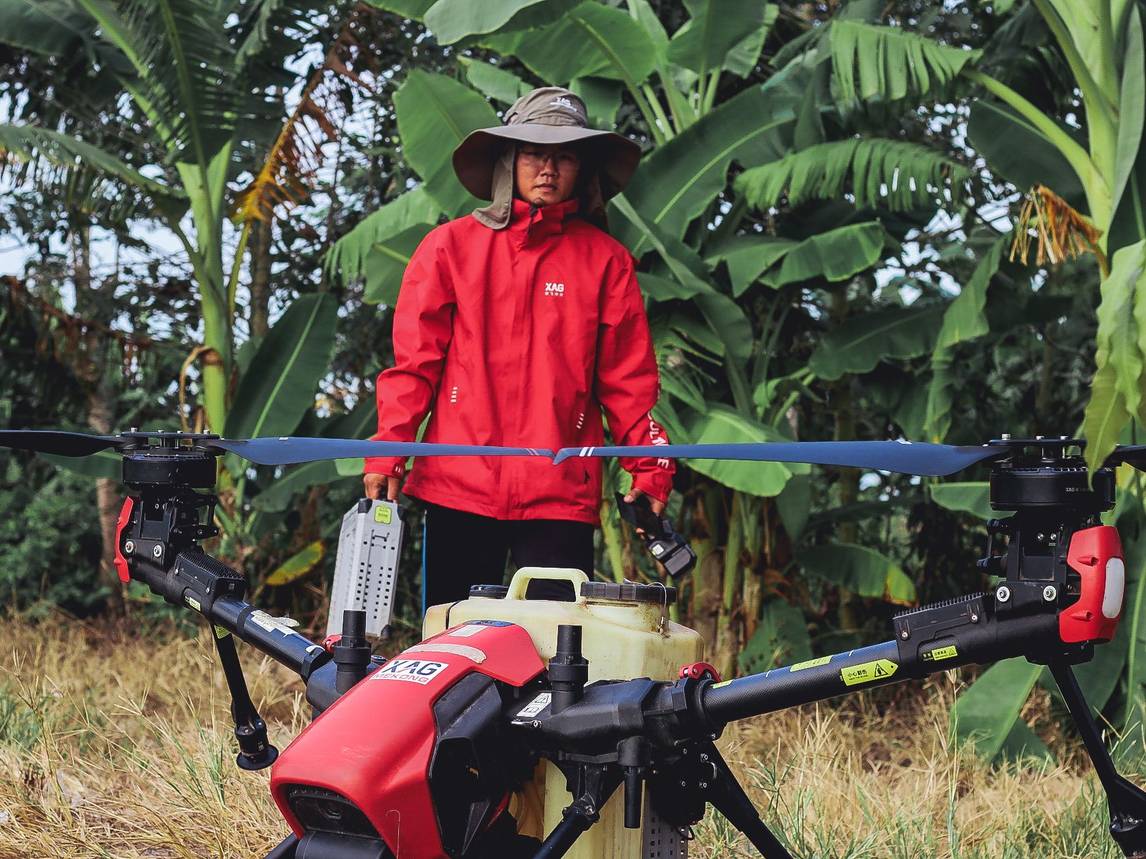 Suited up in the XAG-branded sunshield outfit, the drone pilot gets himself a thorough protection to avoid sun burn. It only takes a few seconds to assemble the battery into the V40 agricultural drone.